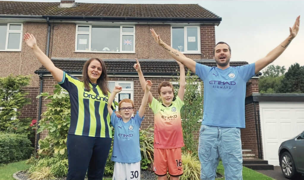 A family sing a sing "Blue Moon" outside their house