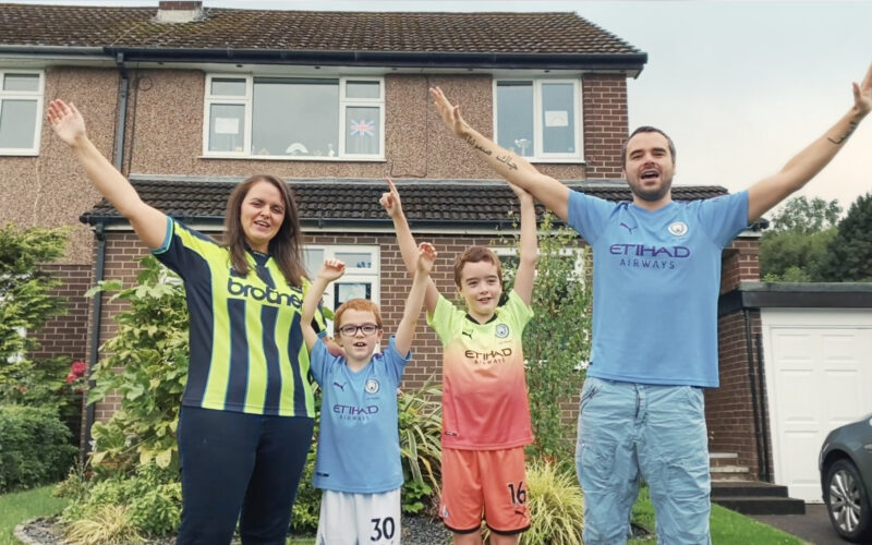 A family sing a sing "Blue Moon" outside their house