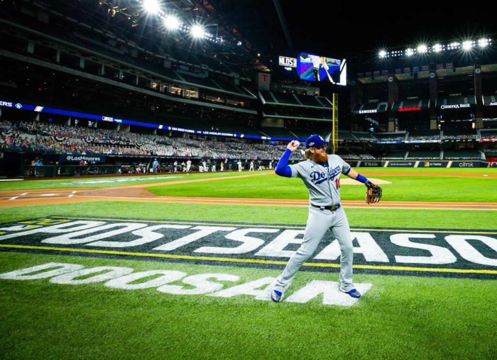 Baseball player stands next to a Doosan logo printed on the field of play