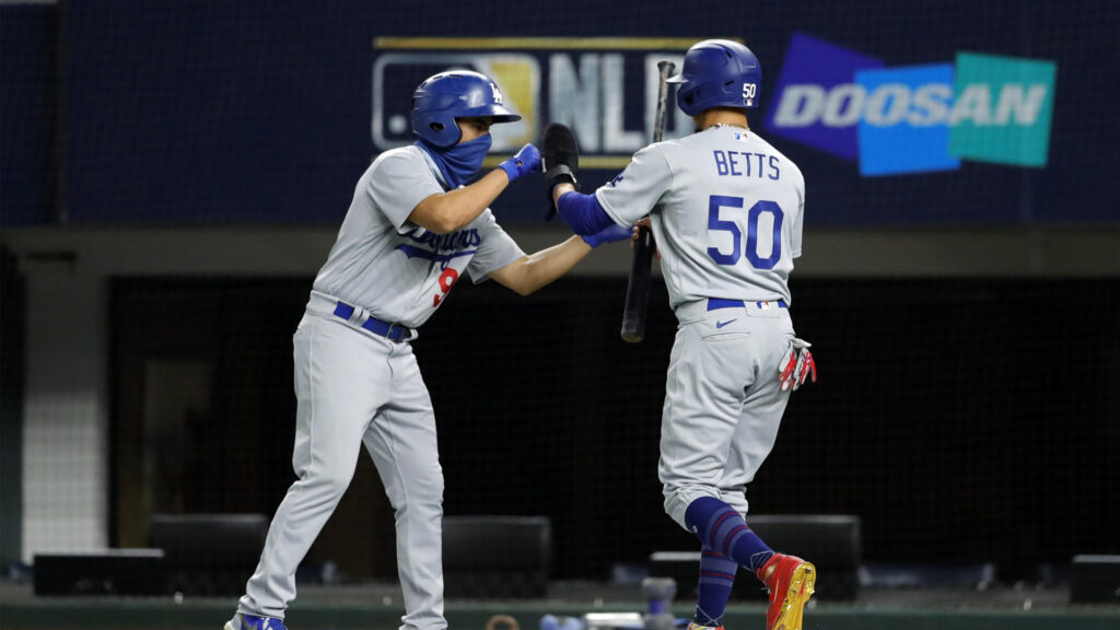 Baseball player exchanges bat with team mate